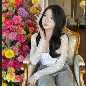 Girl Sitting Beside a Colorful Flower Display