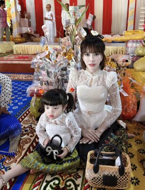 Mother and daughter in traditional attire at a cultural event.