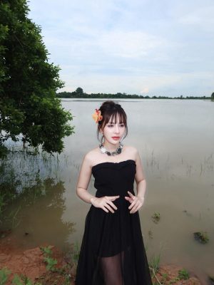 Girl by the lakeside in a black dress