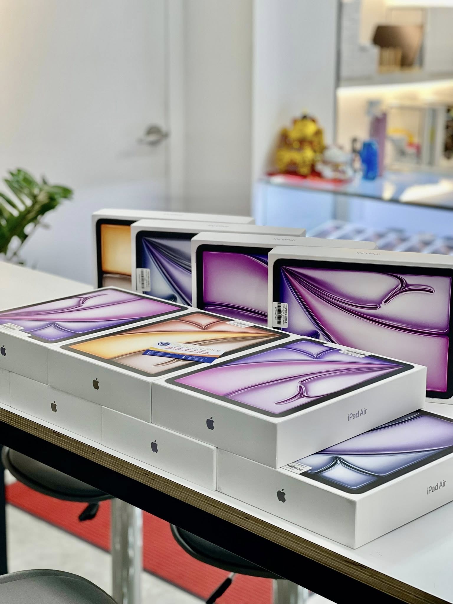 A display of multiple boxed iPad Air devices arranged neatly on a table.